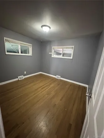 a view of empty room with wooden floor