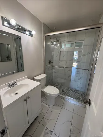 a bathroom with a toilet sink shower and mirror