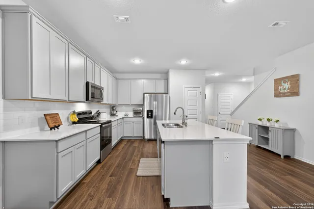 a large kitchen with stainless steel appliances lots of counter space and wooden floor