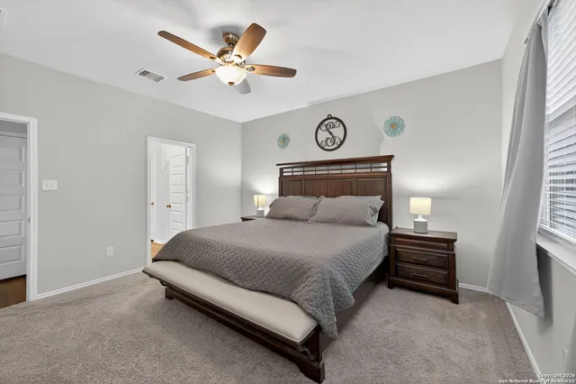 a bedroom with a bed and a ceiling fan
