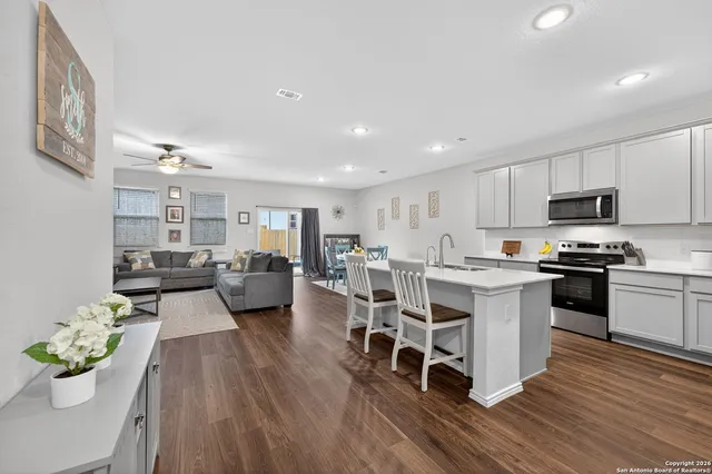 a large white kitchen with lots of counter space a sink and appliances
