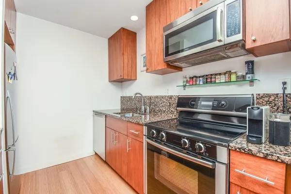 a kitchen with stainless steel appliances granite countertop a stove and a microwave