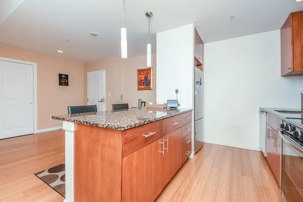 a kitchen with granite countertop a sink and a refrigerator