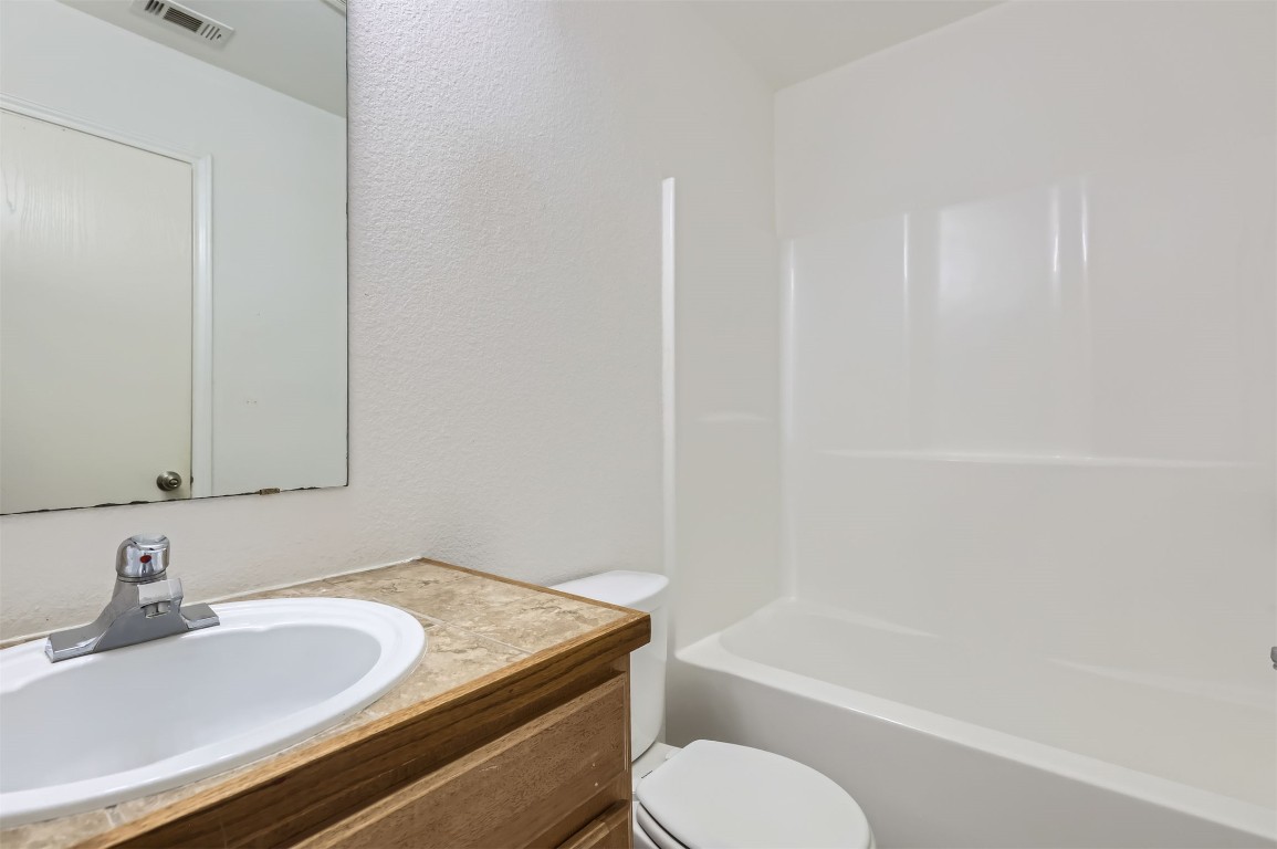224 Copper Lane Jarrell, TX 76537 - Photo 10 of 11 a bathroom with a granite countertop sink toilet and shower