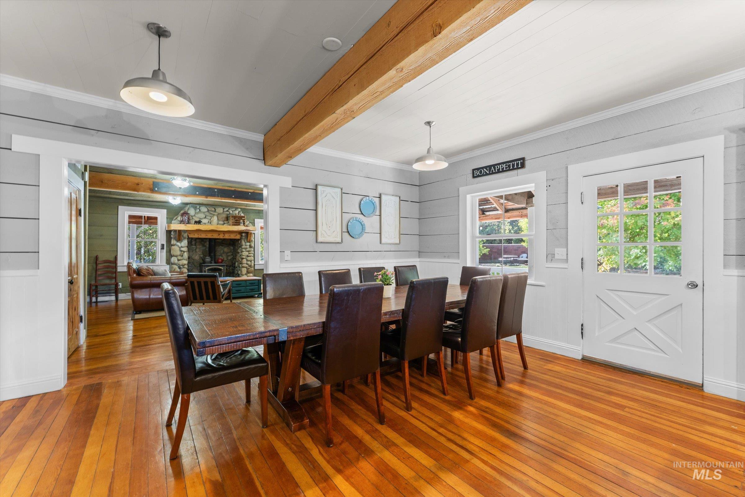 315 South Middlefork Road Garden Valley, ID 83622 - Photo 13 of 49 Dining area featuring light wood-style floors, crown molding, beam ceiling, plenty of natural light, and a fireplace