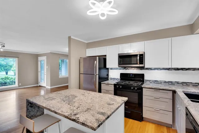 a kitchen with stainless steel appliances granite countertop a sink dishwasher stove top oven and refrigerator