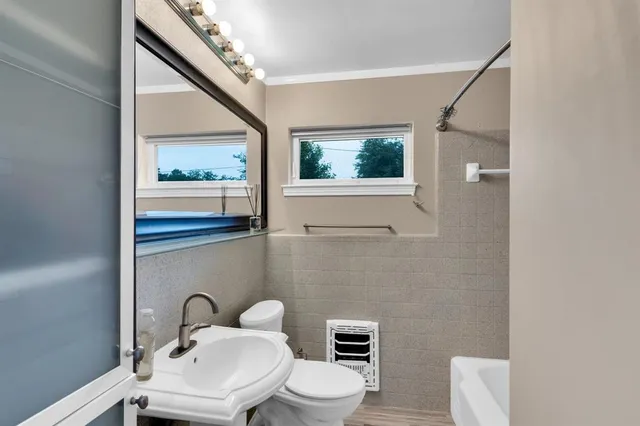 a bathroom with a toilet sink and mirror