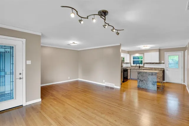 a view of kitchen and hall with wooden floor