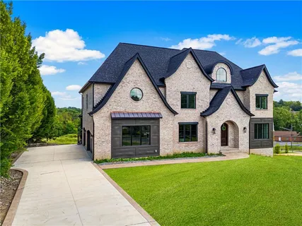 a front view of a house with yard and green space