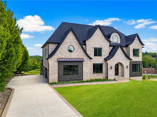 a front view of a house with yard and green space