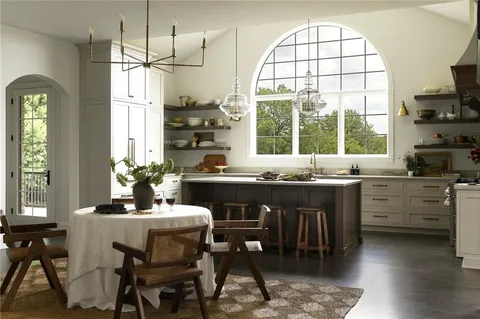 a kitchen with a table chairs sink and cabinets