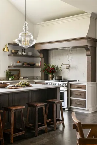 a kitchen with a stove a chandelier and wooden cabinets