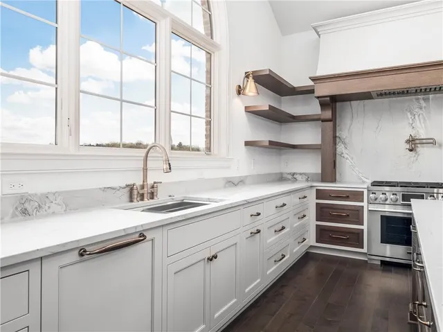 a kitchen with stainless steel appliances granite countertop a sink and cabinets with wooden floor