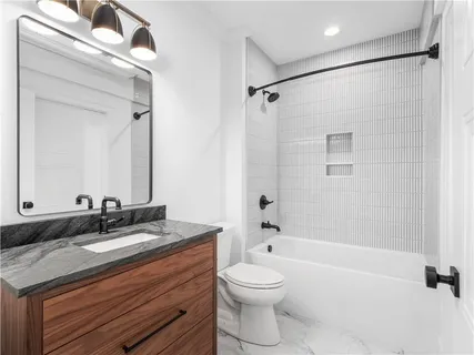 a bathroom with a granite countertop sink a toilet and a mirror