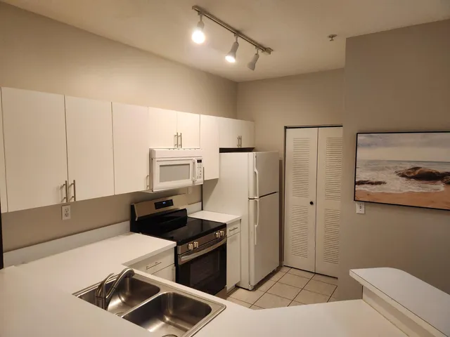 a kitchen with a refrigerator and a stove top oven