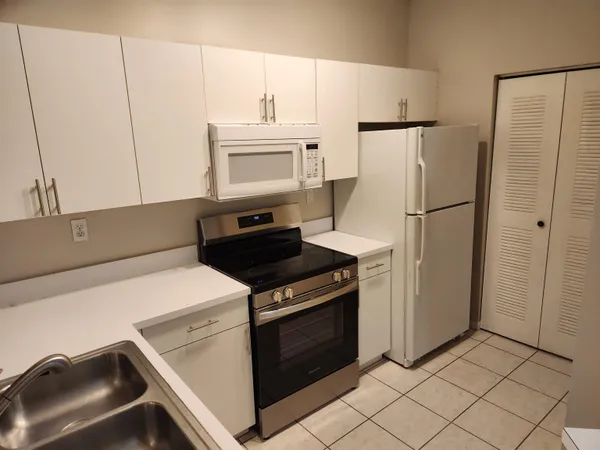 a kitchen with white cabinets and white appliances