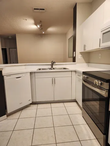 a kitchen with a stove a sink and a refrigerator