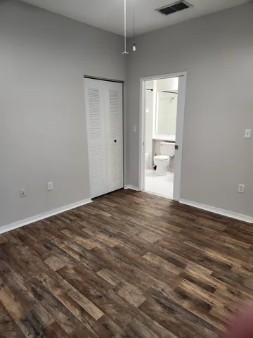a view of empty room with wooden floor and window