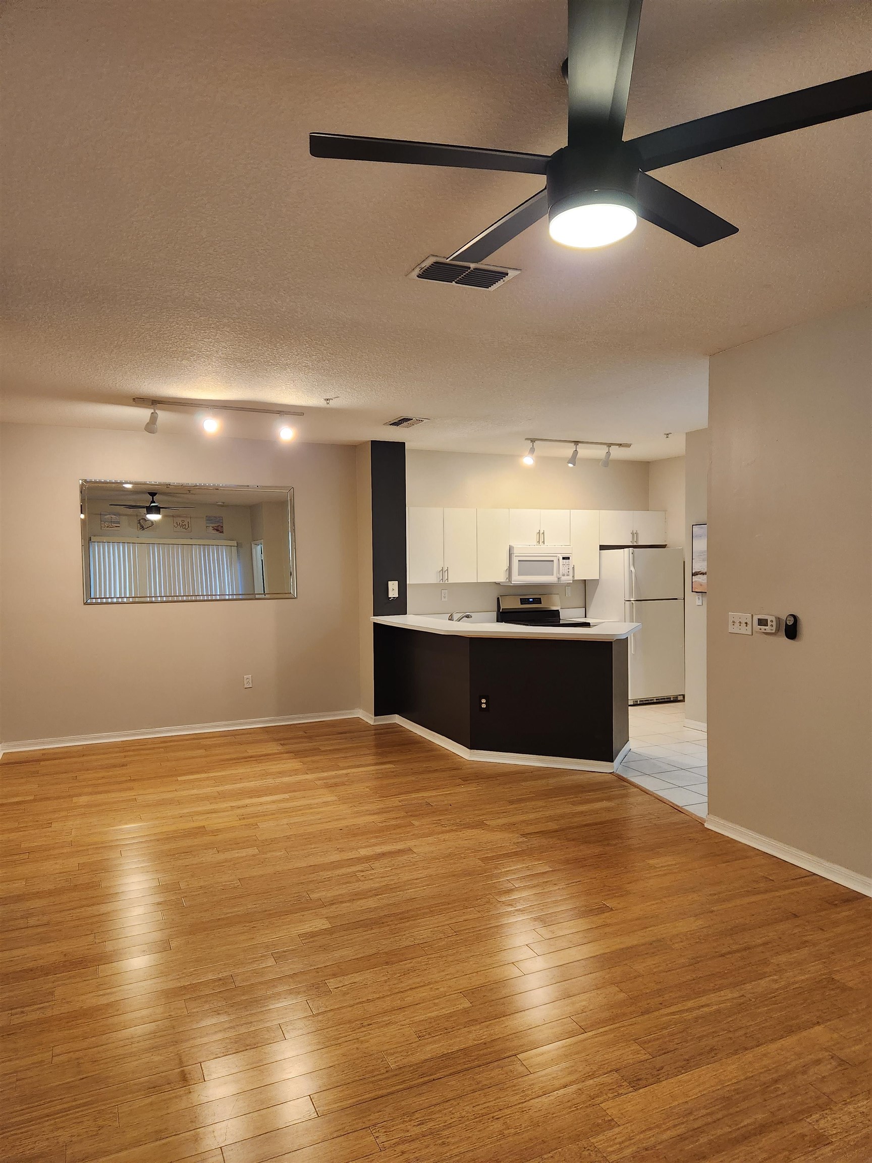 510 Florida Club Boulevard, Unit 101 St. Augustine, FL 32084 - Photo 7 of 37 a view of kitchen and empty room with wooden floor