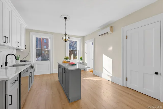 a kitchen that has a lot of cabinets stainless steel appliances and a window