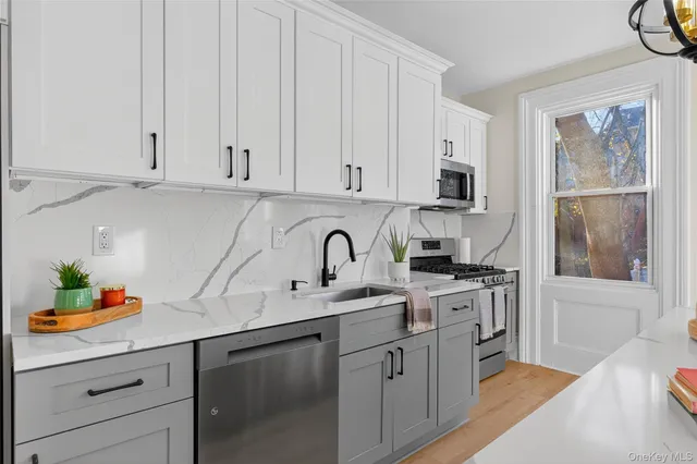 a kitchen with stainless steel appliances granite countertop a sink a stove and cabinets