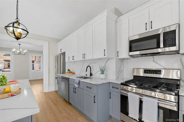 a kitchen with stainless steel appliances granite countertop a sink a stove and a microwave