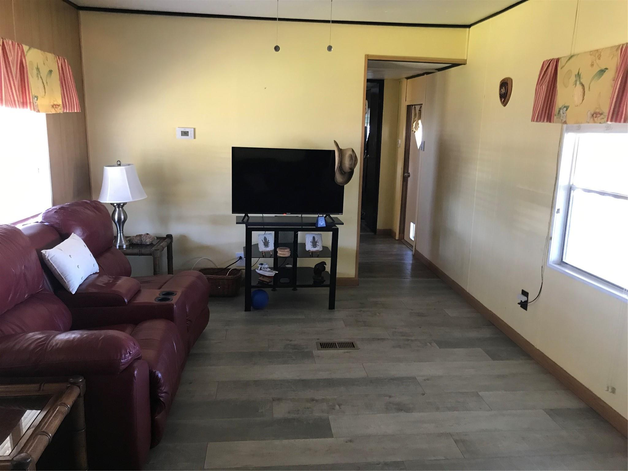1379 Chobee Street Okeechobee, FL 34974 - Photo 5 of 13 a living room with furniture and a flat screen tv