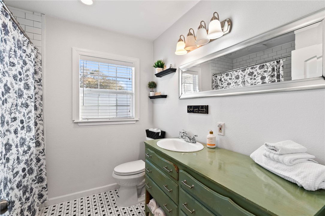 302 Cole Street Corpus Christi, TX 78404 - Photo 15 of 40 a bathroom with a granite countertop sink a toilet and a window