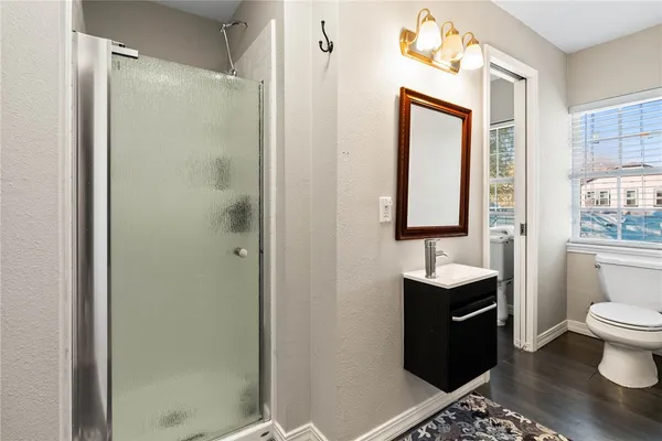 a bathroom with a sink a toilet and shower