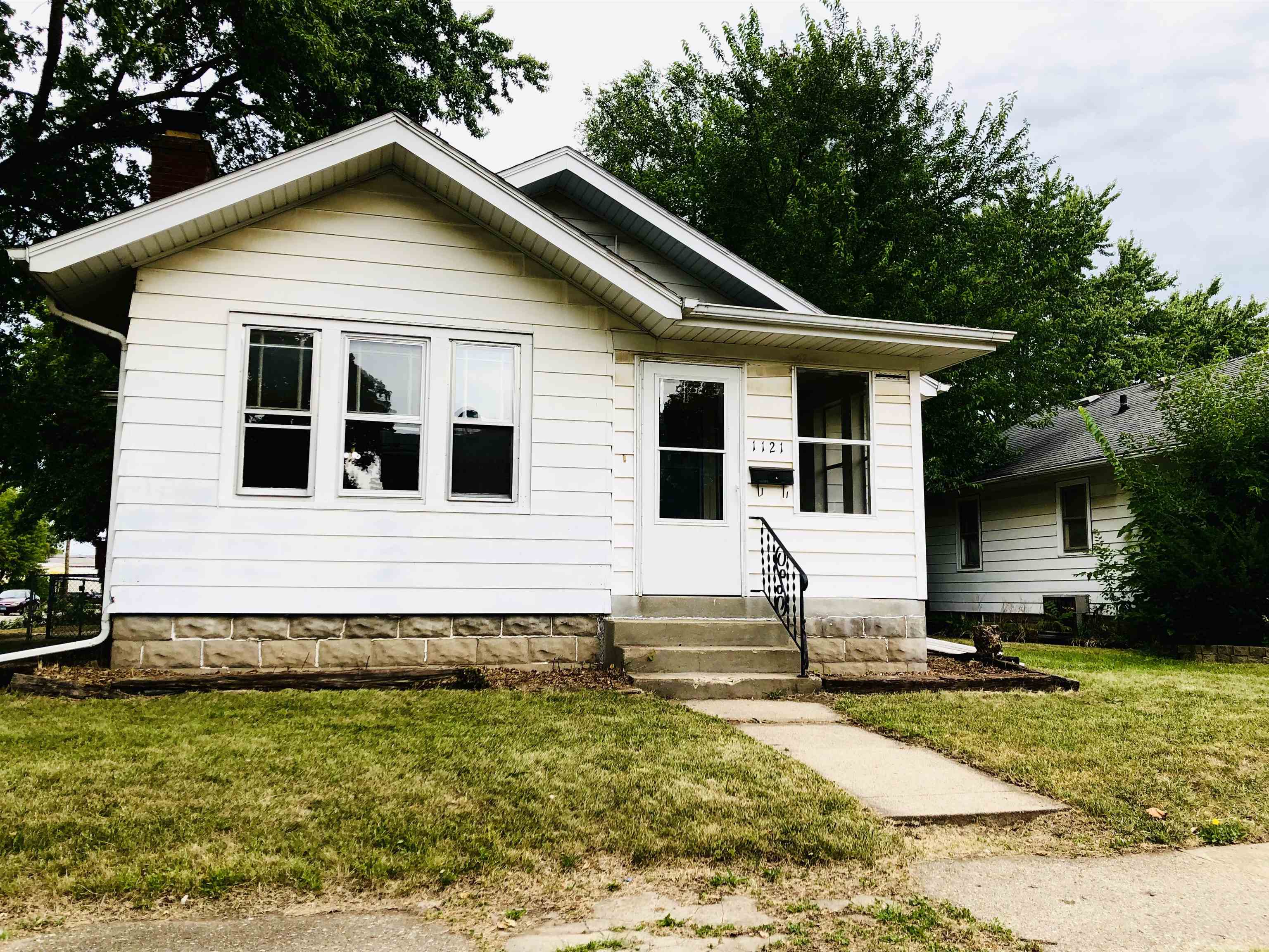 1121 Van Wie Avenue Rockford, IL 61103 - Photo 1 of 2 a view of a white house with a yard next to a road
