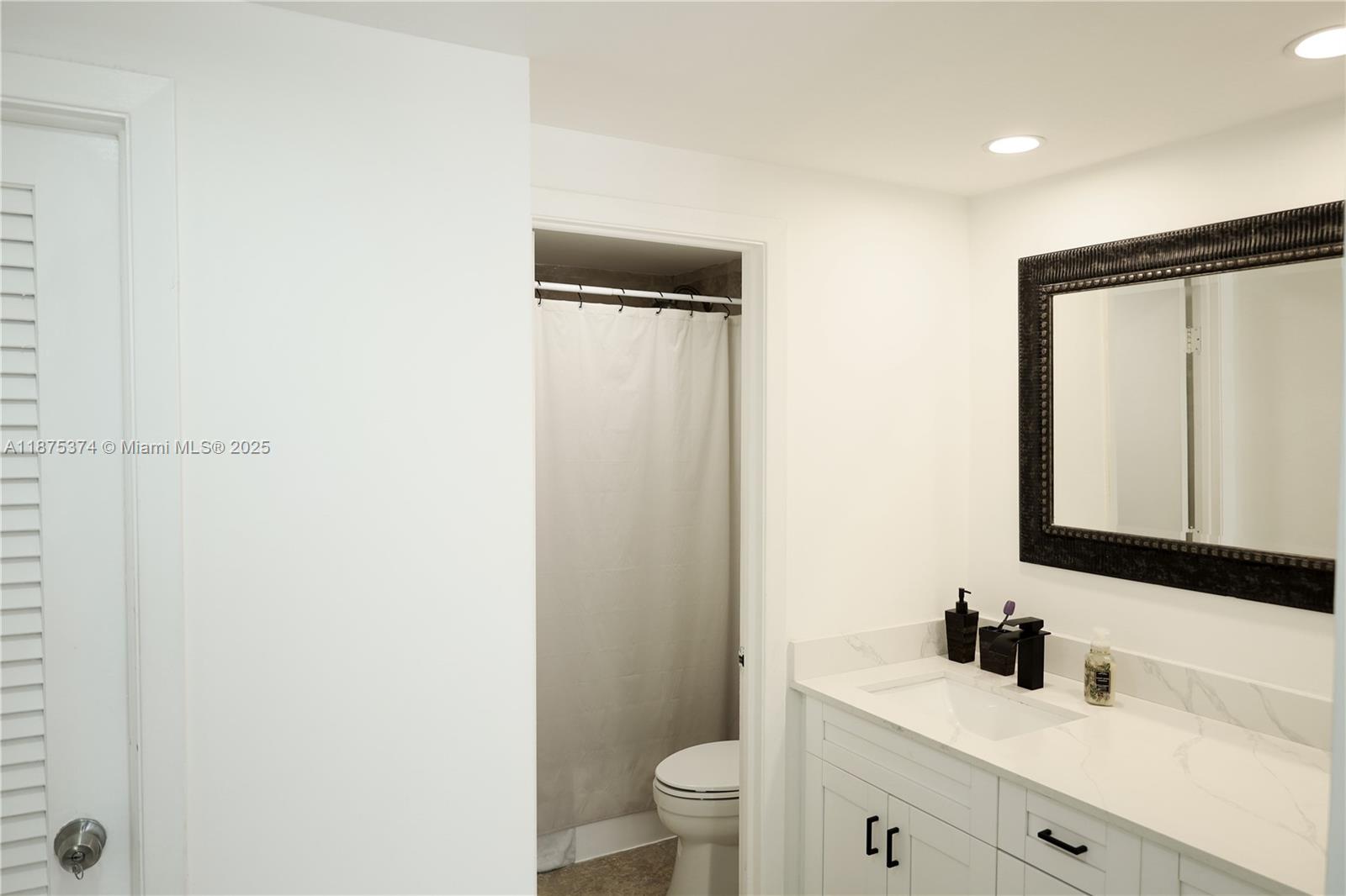 500 Bayview Drive, Unit 230 Sunny Isles Beach, FL 33160 - Photo 26 of 48 a bathroom with a sink a toilet a mirror and shower
