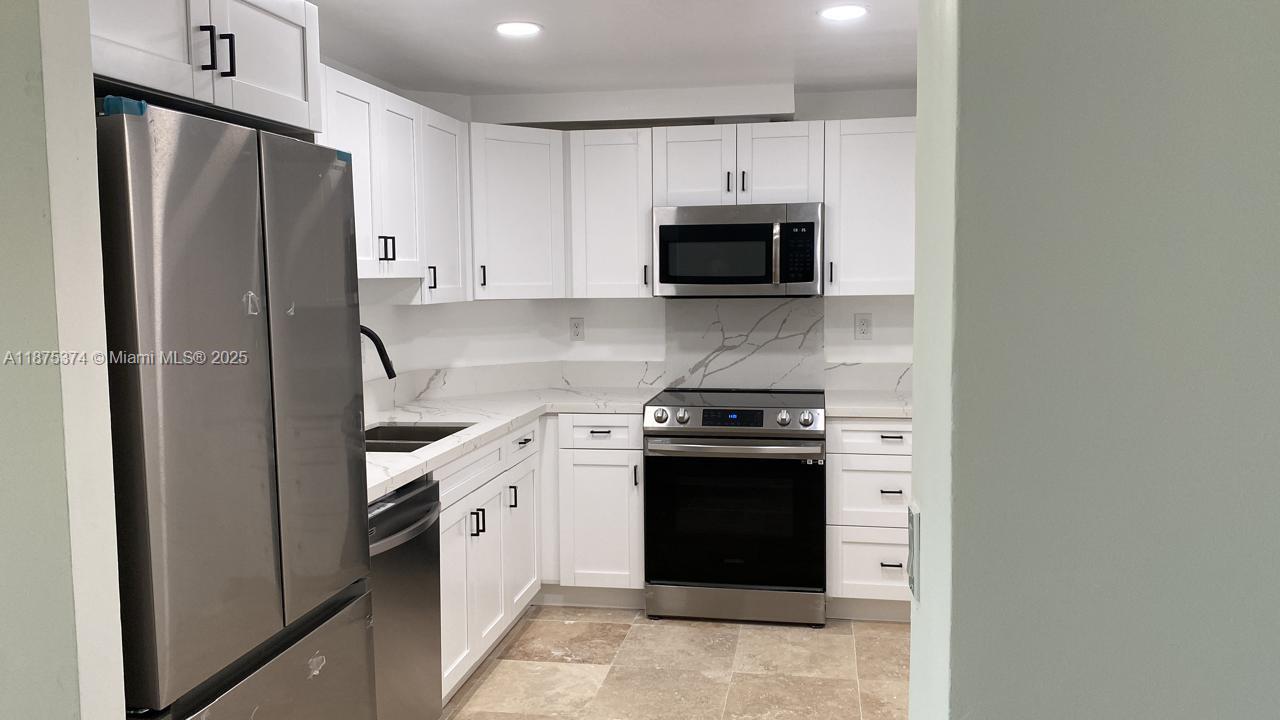 500 Bayview Drive, Unit 230 Sunny Isles Beach, FL 33160 - Photo 6 of 48 a kitchen with stainless steel appliances a stove microwave and refrigerator