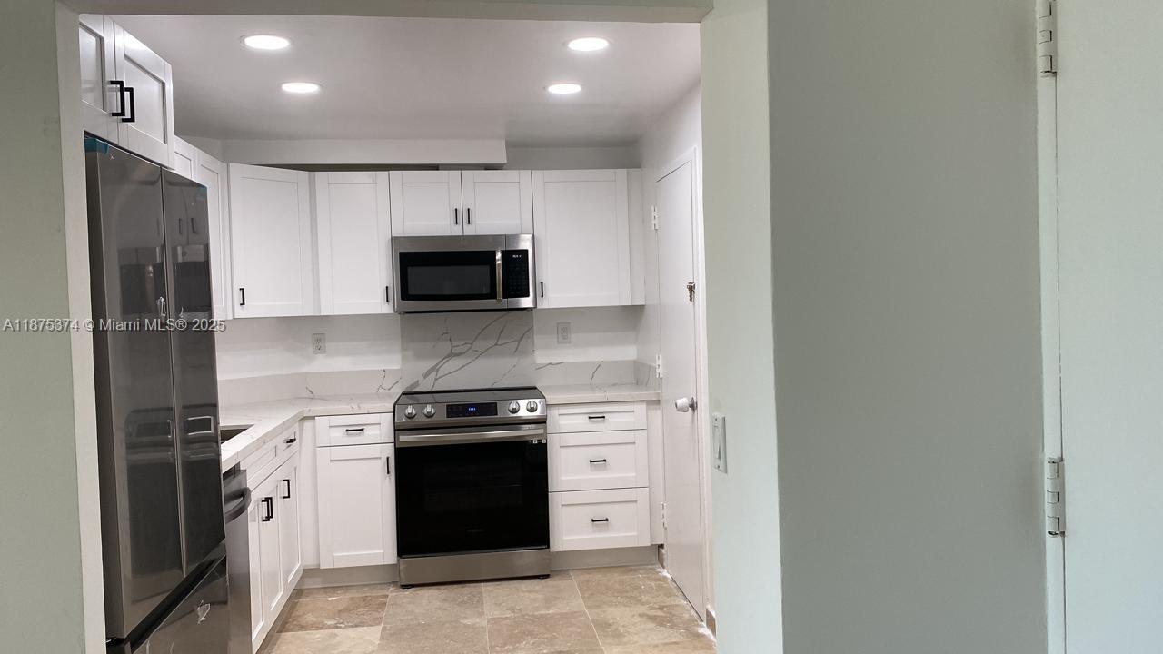 500 Bayview Drive, Unit 230 Sunny Isles Beach, FL 33160 - Photo 7 of 48 a kitchen with a stove and a refrigerator
