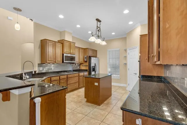 a kitchen with stainless steel appliances granite countertop a sink counter space cabinets and a large window