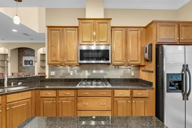 a kitchen with stainless steel appliances granite countertop a refrigerator and cabinets