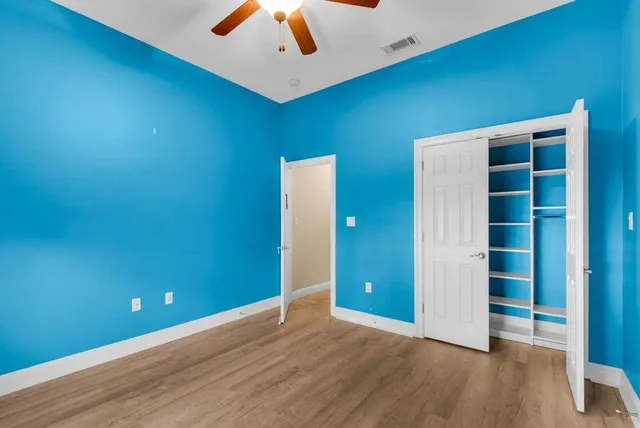 an empty room with wooden floor and closet