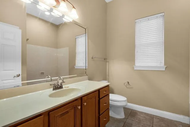 a bathroom with a sink a toilet and a mirror