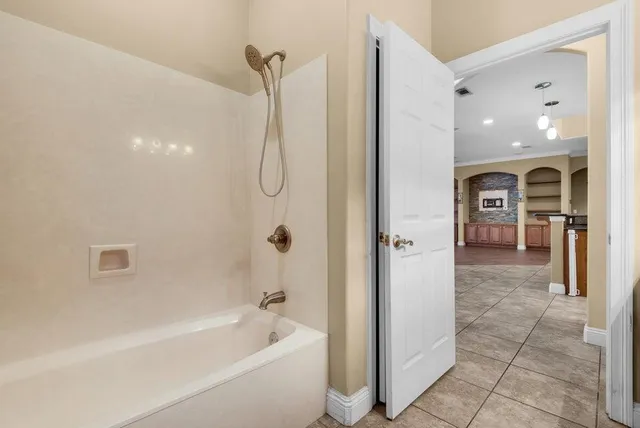 a bathroom with a bathtub a shower and a mirror