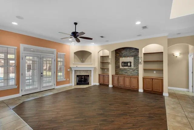 a view of empty room with a fireplace and wooden floor