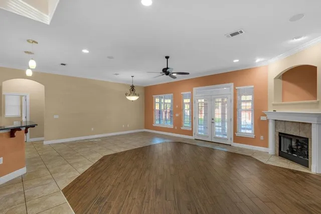 a view of an empty room with wooden floor and a fireplace