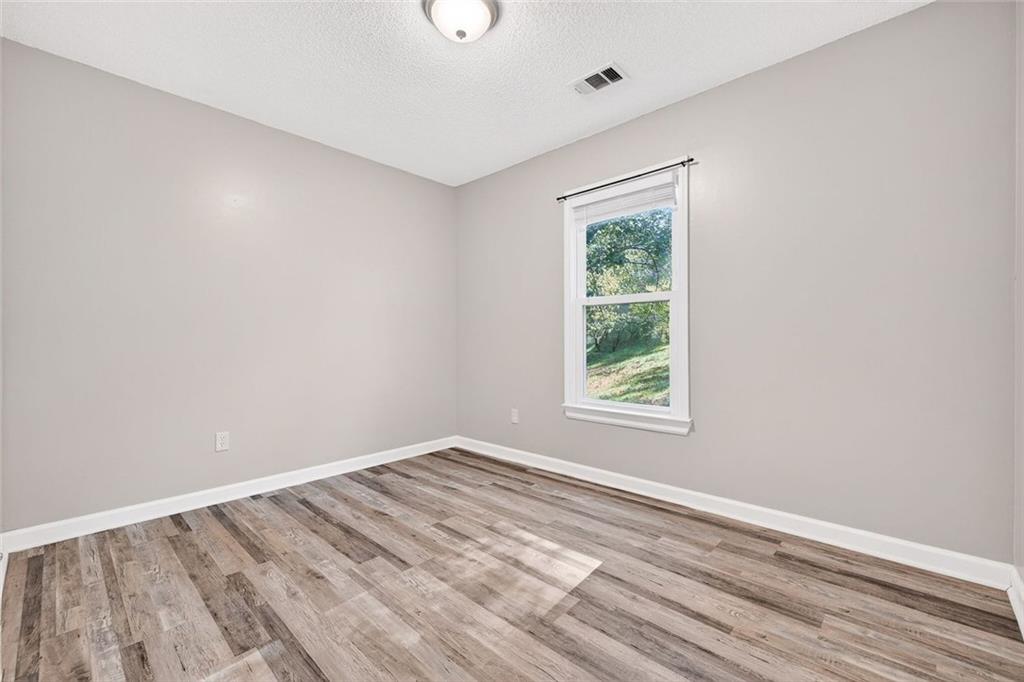 255 Lowry Street Ball Ground, GA 30107 - Photo 12 of 29 wooden floor in an empty room with a window