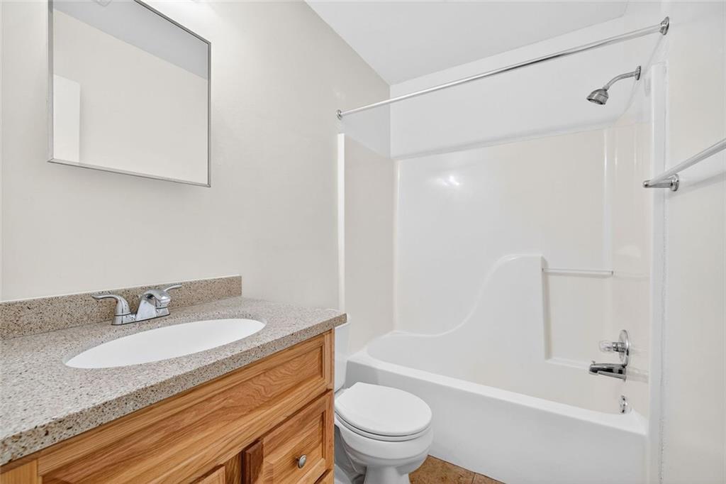 255 Lowry Street Ball Ground, GA 30107 - Photo 13 of 29 a bathroom with a granite countertop sink toilet and shower