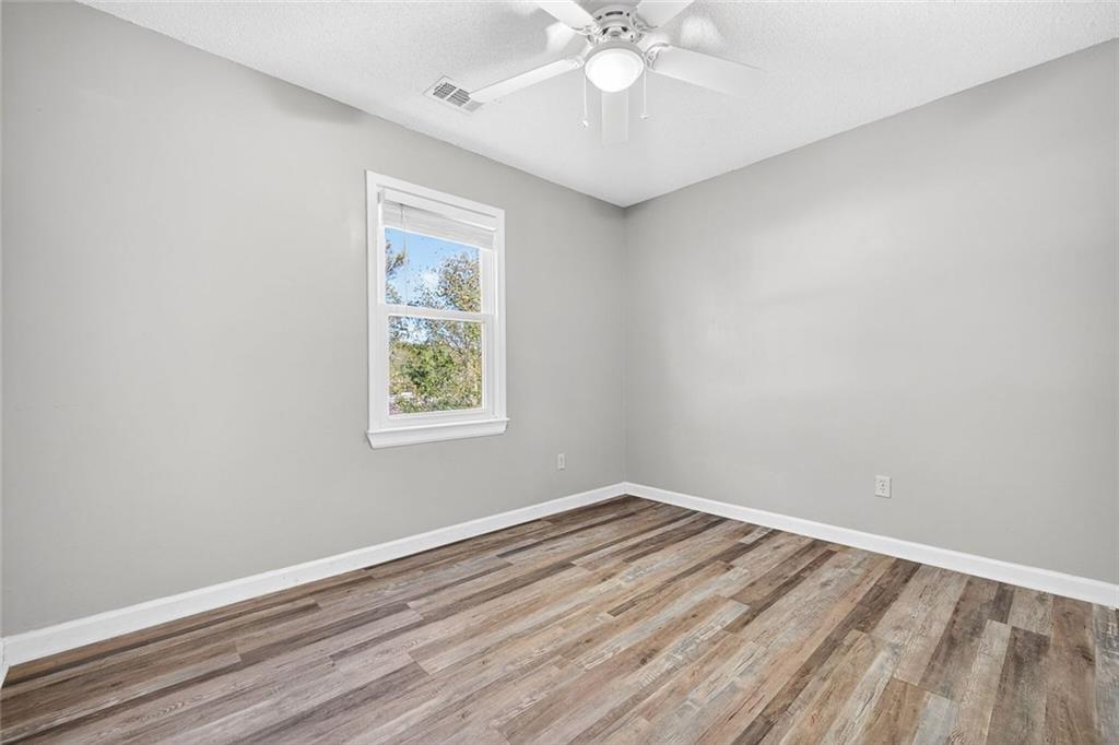 255 Lowry Street Ball Ground, GA 30107 - Photo 14 of 29 wooden floor in an empty room with a window