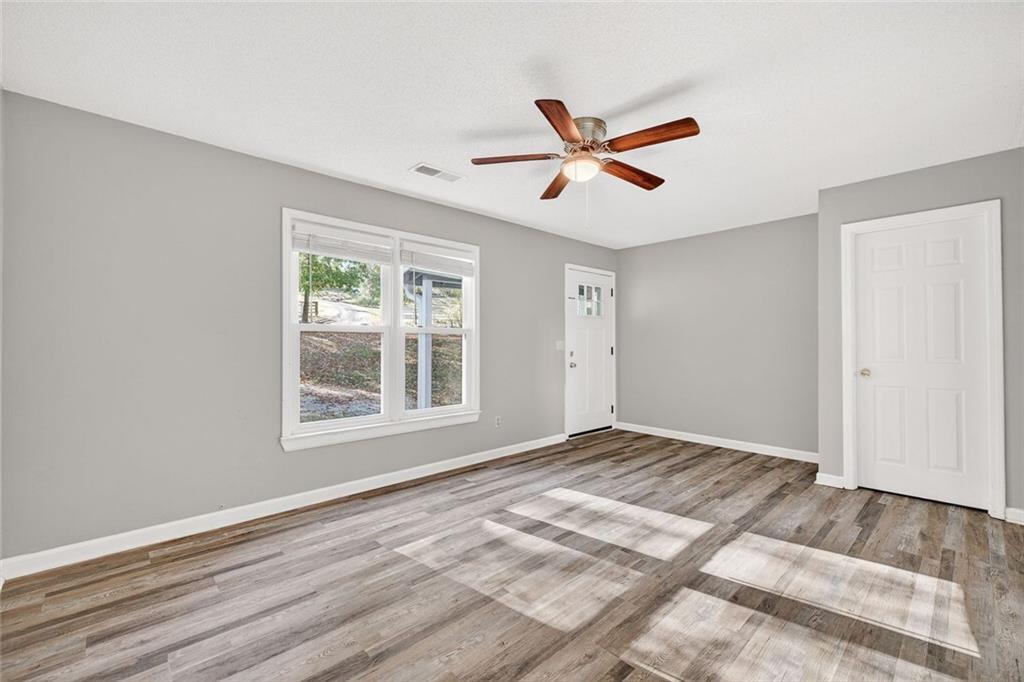 255 Lowry Street Ball Ground, GA 30107 - Photo 3 of 29 a view of empty room with wooden floor and fan