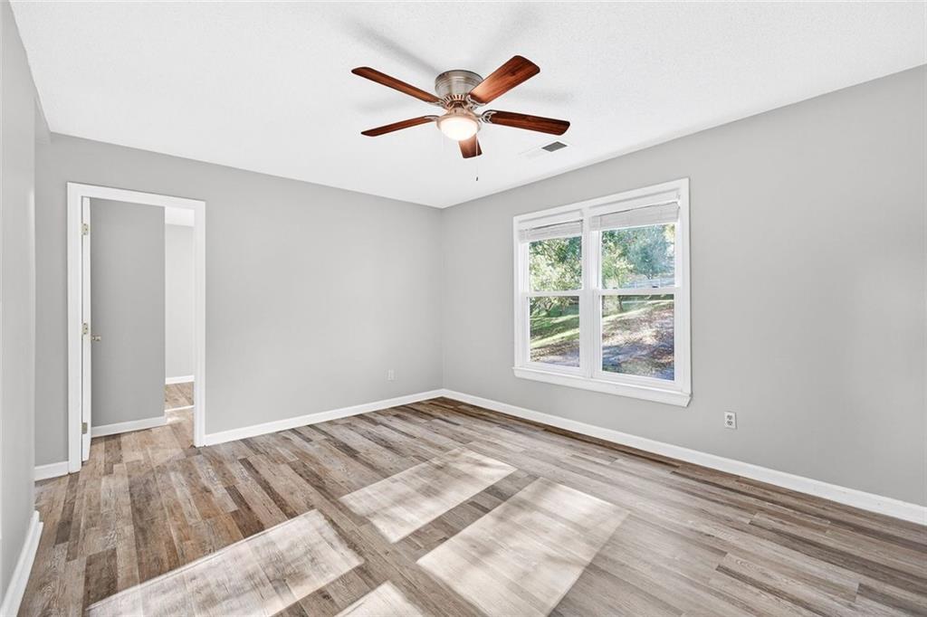 255 Lowry Street Ball Ground, GA 30107 - Photo 4 of 29 a view of a livingroom with a ceiling fan and wooden floor