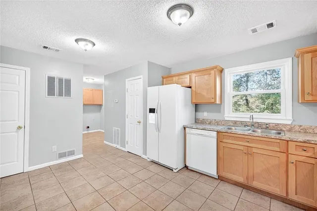 a view of a hallway with wooden floor and a kitchen