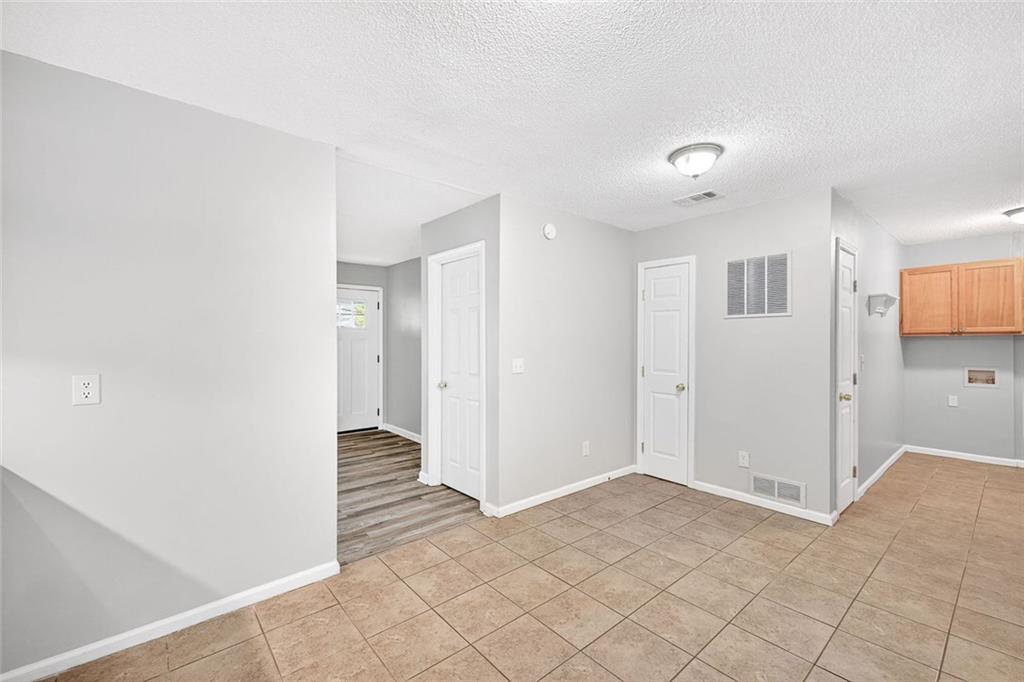 255 Lowry Street Ball Ground, GA 30107 - Photo 8 of 29 a view of a hallway with wooden floor and a kitchen