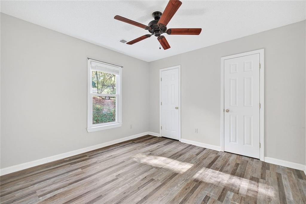 255 Lowry Street Ball Ground, GA 30107 - Photo 10 of 29 a view of empty room with wooden floor and fan