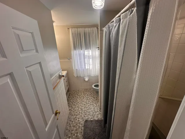 a bed sitting in a spacious bedroom next to a window