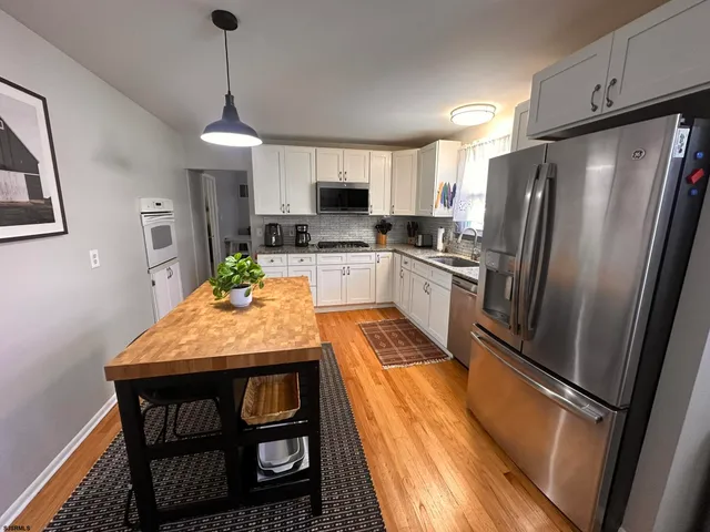 a kitchen with stainless steel appliances granite countertop sink microwave and refrigerator